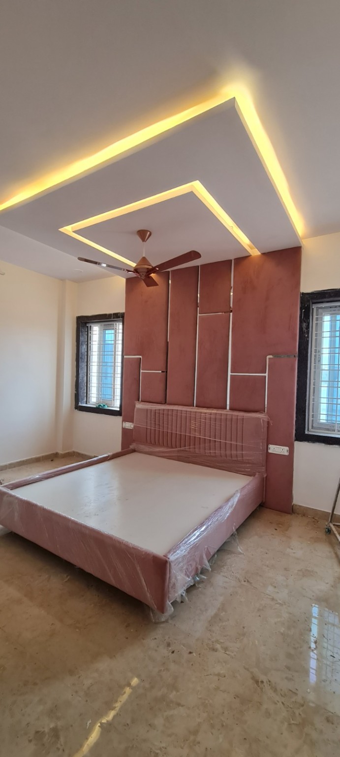 Completed bedroom with upholstered bed and illuminated false ceiling